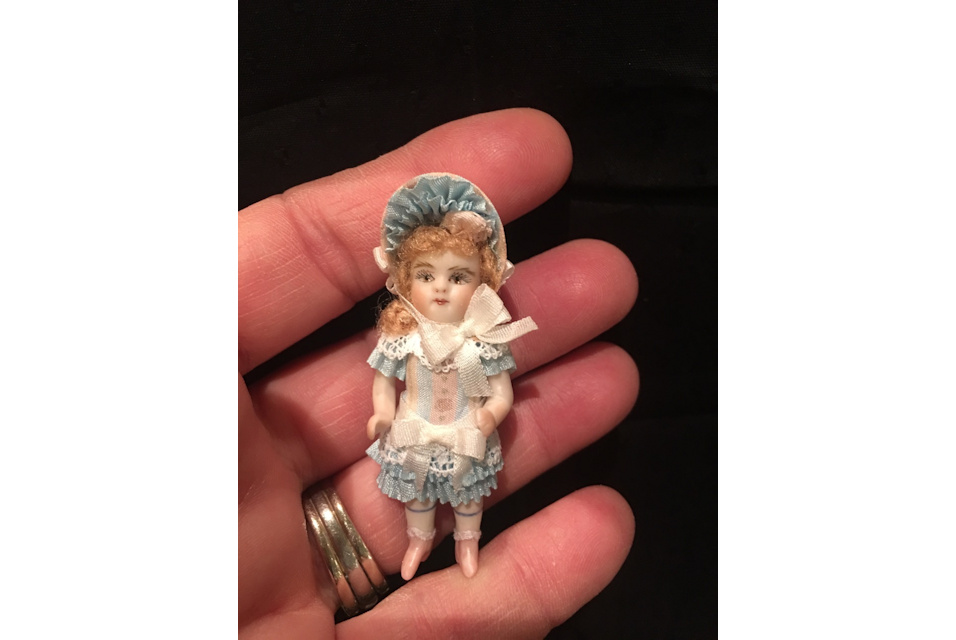 doll in hand light blue bonnet