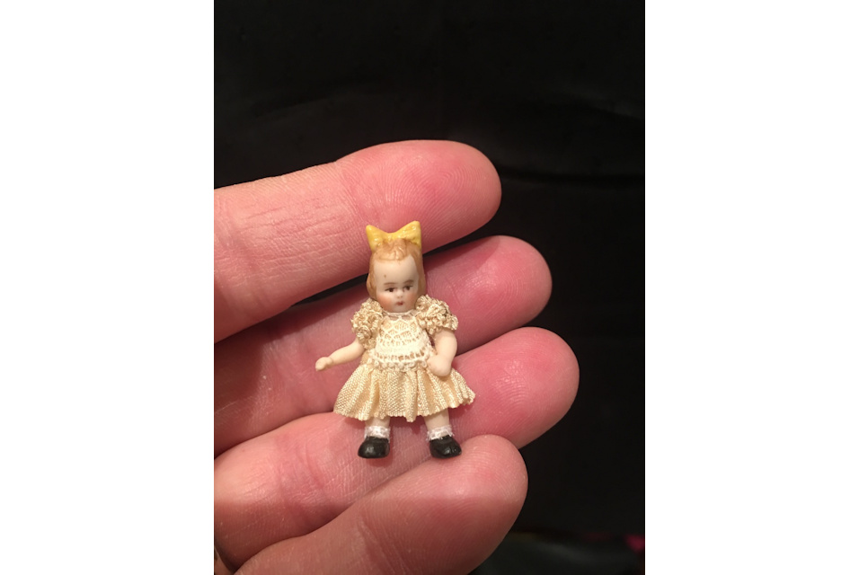 doll in hand yellow bow